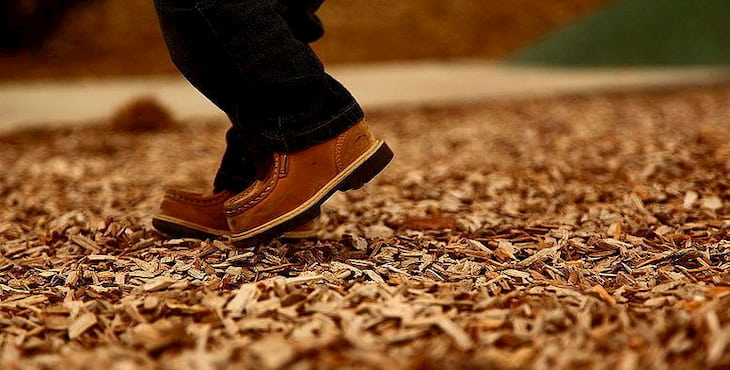 man walking on wood chips