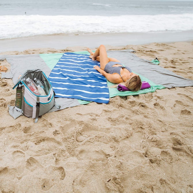 girl laying on a bamboo beach towel
