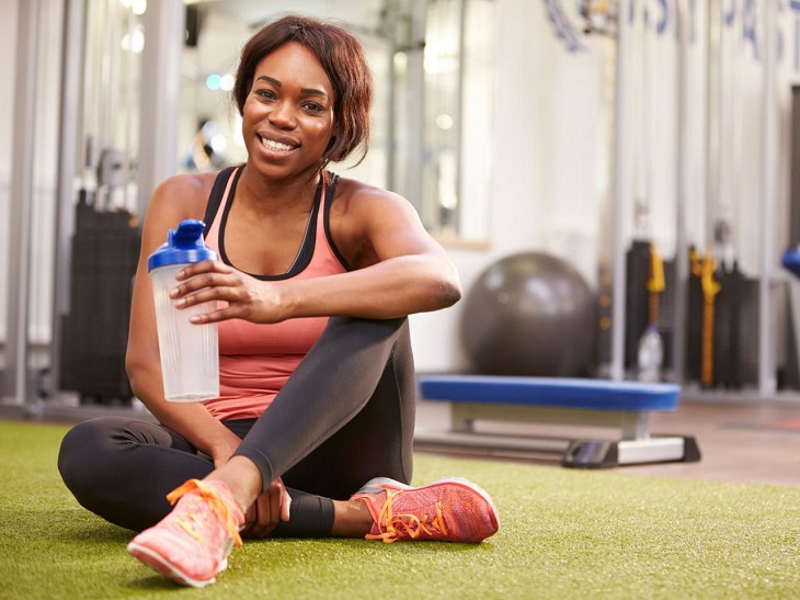 girl sitting in gym with bottle