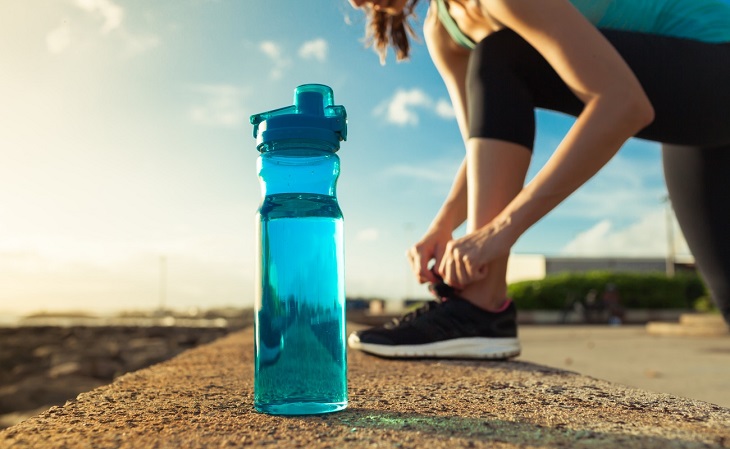 picture of bottle and women tying her shoe