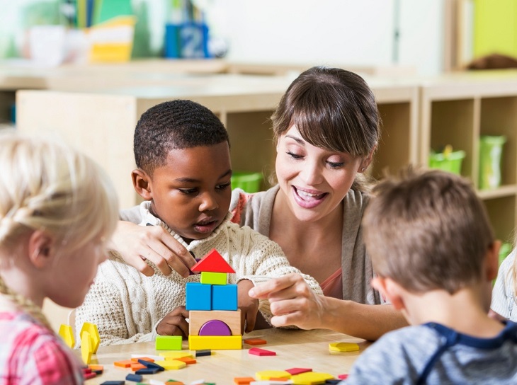 teacher helping a kid with a stem toy