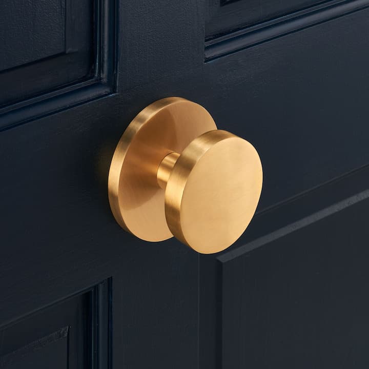 modern gold door knob on black door