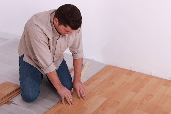 man installing vinyl flooring for home