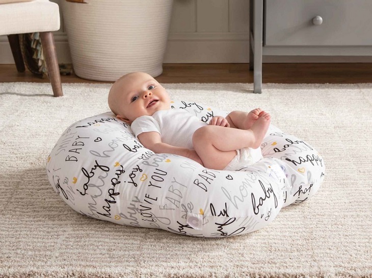 picture of a baby lying on a cushion on the floor 