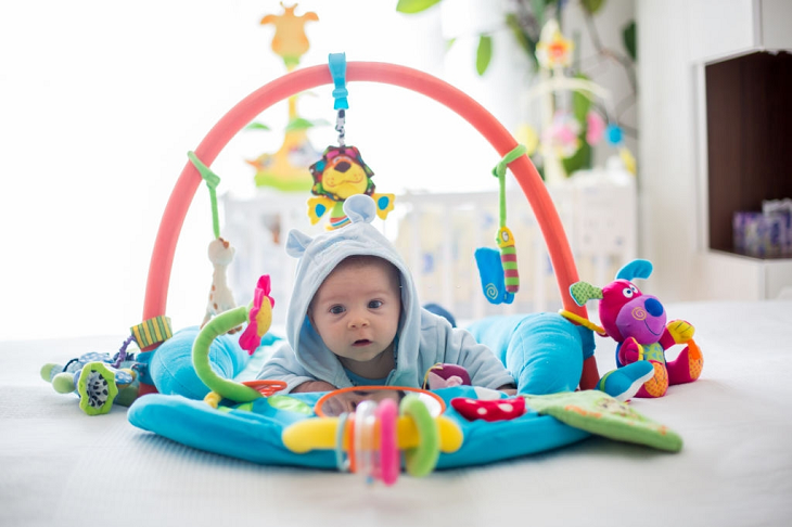 picture of a baby on the floor playing with toys