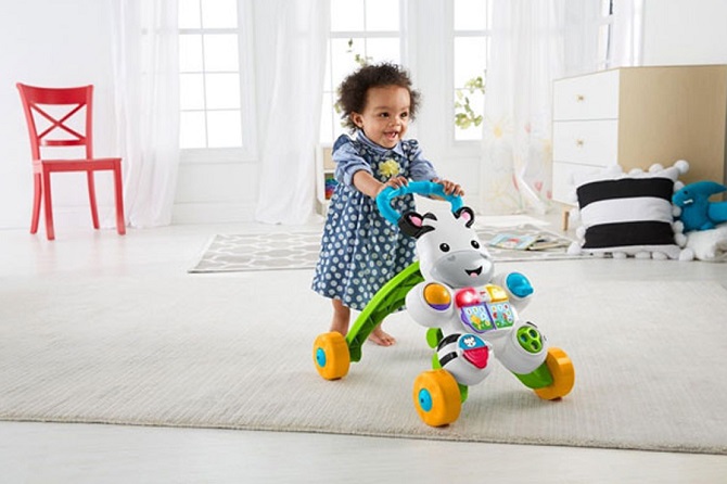 picture of a baby girl with a baby activity cenre on a rug