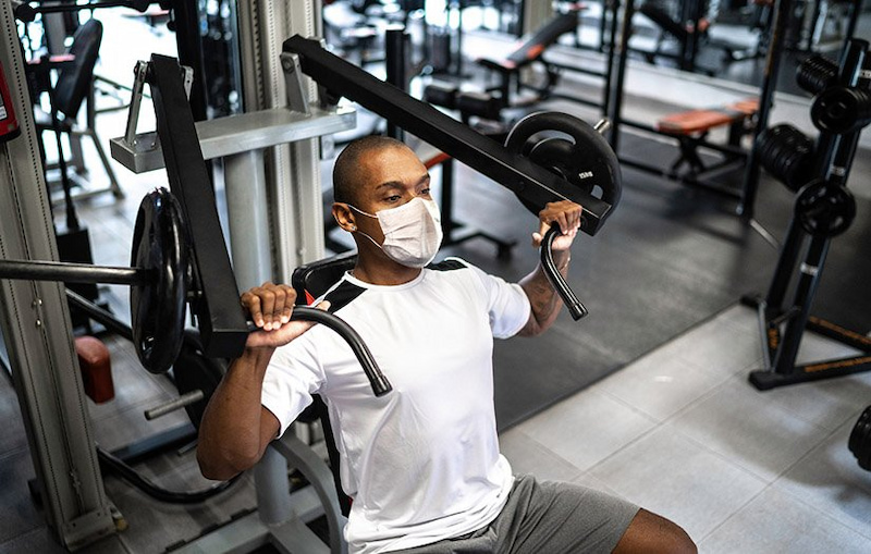 Man weightlifting a machine equipped with adjustable stop