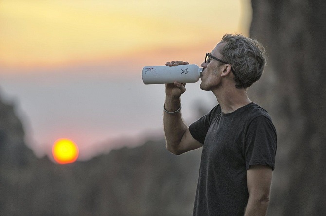 man drinking water from a hydro flask water bottle 