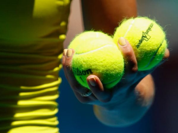 Women holding two tennis balls