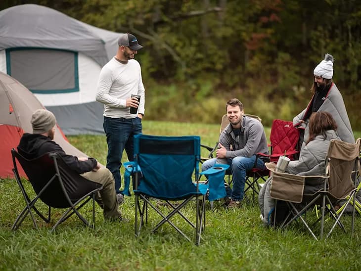 friends sitting on folding camping chairs