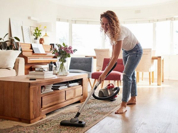 Woman vacuuming the carpet in the living room