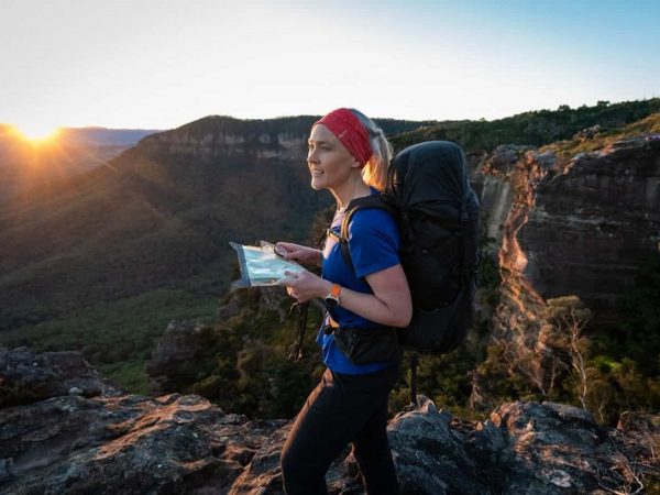 picture of a woman traveling in nature with map and compas
