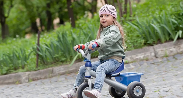picture of a kid using kids trike outside
