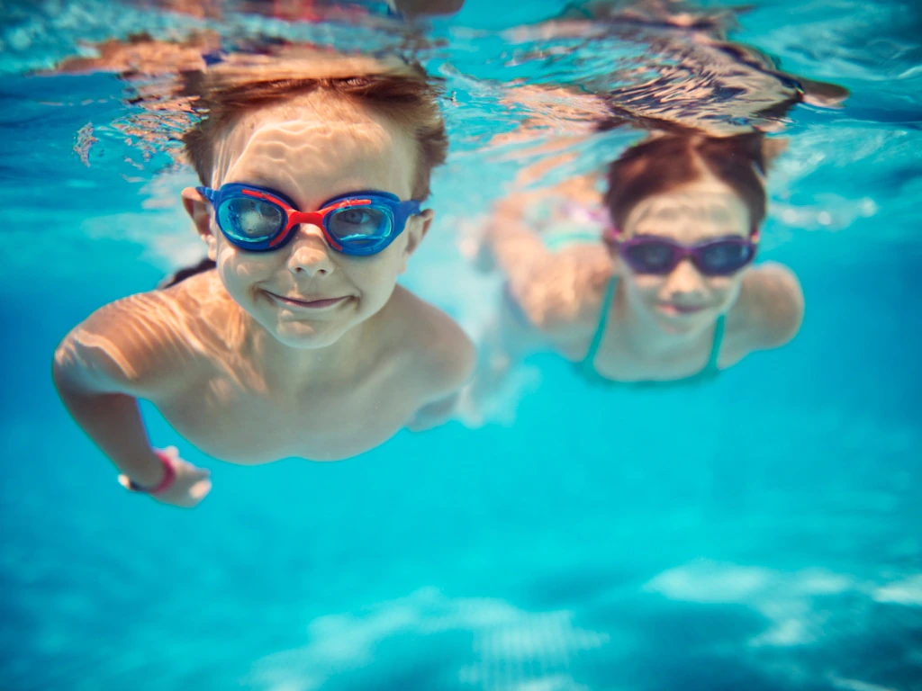 two kids wearing goggles in the water 