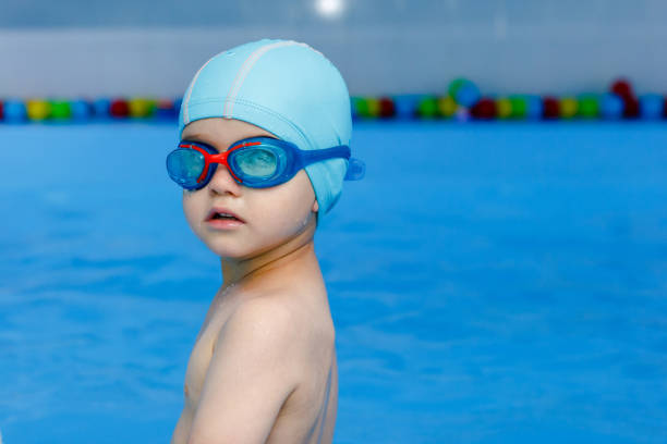 professional young swimmer in blue cap ready to swim in pool 