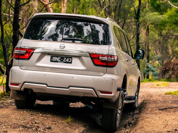 White Nissan Y62 Patrol driven in nature