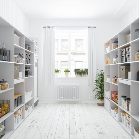 Walk-in pantry with white shelves stocked with food containers and kitchenware.