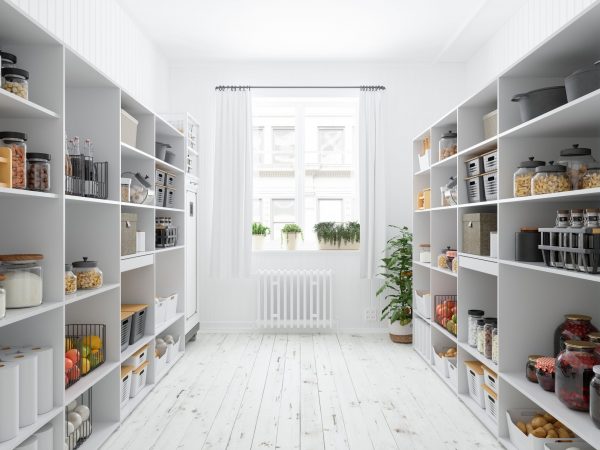 Walk-in pantry with white shelves stocked with food containers and kitchenware.