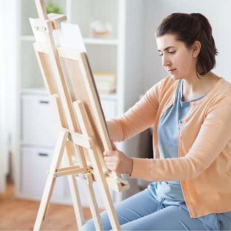 woman painting on paint easel