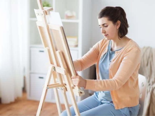 woman painting on paint easel